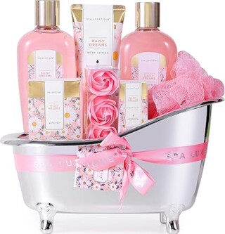 Elegant spa gift set in a mini bathtub, featuring pink Daisy Dreams lotions, body wash, soap, and bath accessories, perfect for relaxation and pampering